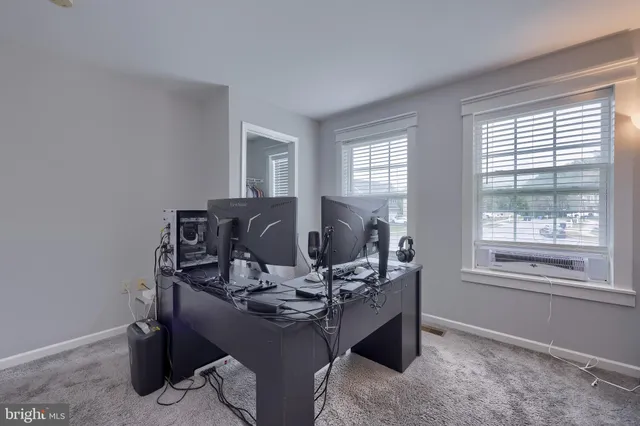 a view of a workspace with furniture and a window