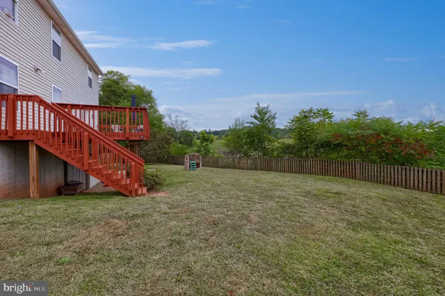a view of a backyard with plants and wooden fence