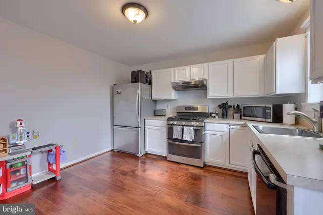 a kitchen with granite countertop white cabinets and white appliances