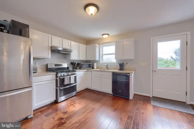 a kitchen with a refrigerator stove and wooden cabinets
