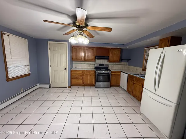 a kitchen with a refrigerator a sink and a stove top oven