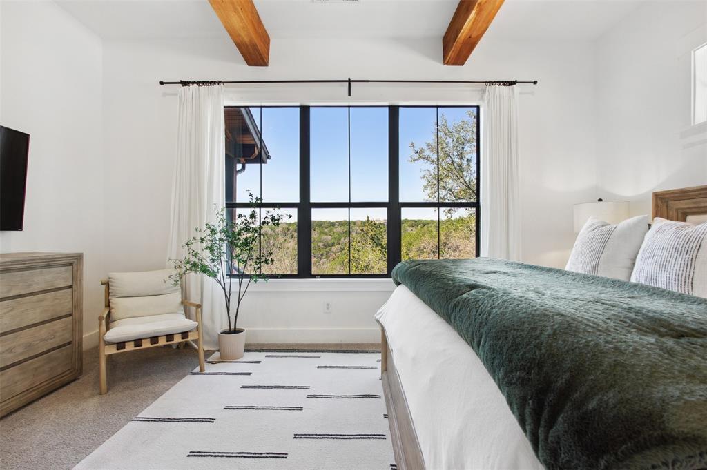 18852 Hidden Ridge Place Jonestown, TX 78645 - Photo 15 of 29 a spacious bedroom with a large bed and a window