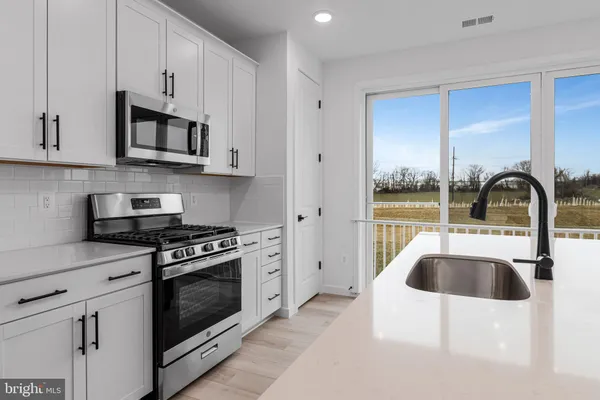 a kitchen with stainless steel appliances granite countertop a sink a stove and refrigerator