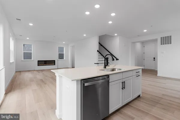 a view of a kitchen with kitchen island a sink stainless steel appliances and cabinets