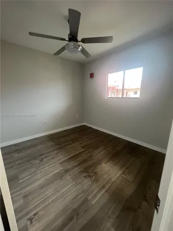 a view of a room with wooden floor and a window