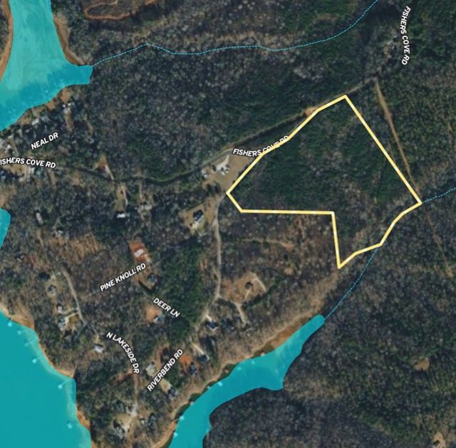 An aerial boundary outline highlights this spacious wooded parcel nestled near the water.
