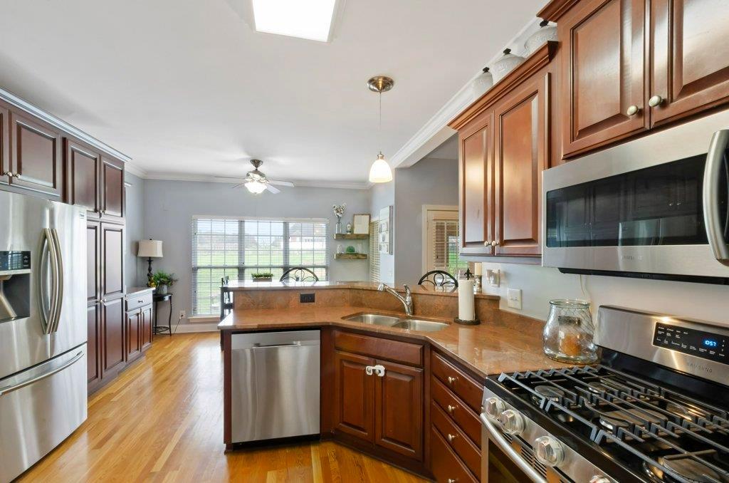619 Lee Road Lebanon, TN 37087 - Photo 6 of 19 a kitchen with stainless steel appliances granite countertop a stove top oven a refrigerator a sink and dishwasher with wooden floor