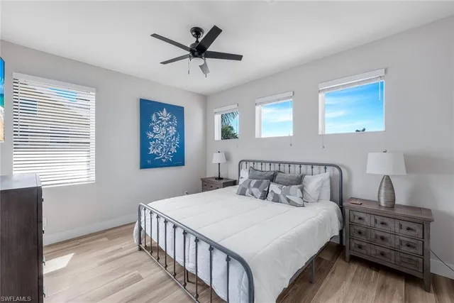 a bedroom with a bed a chandelier and a dresser