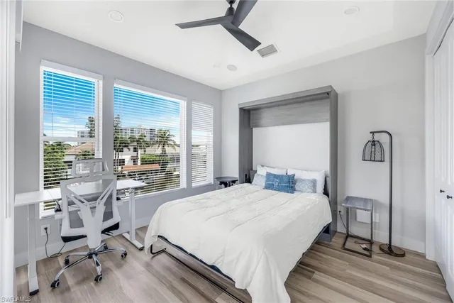 a bedroom with a bed a table and large mirror