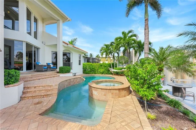 a view of a white house with a yard and plants