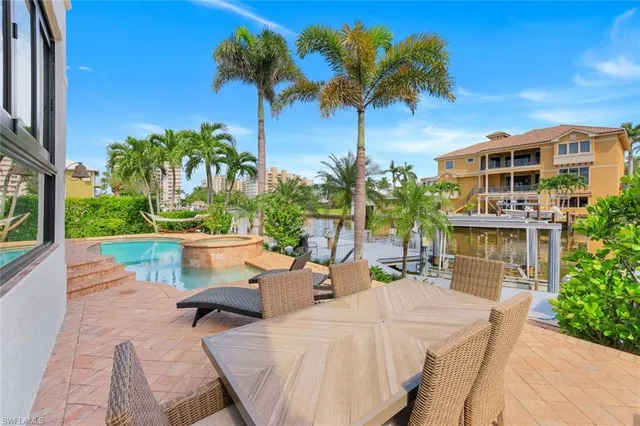 a view of a patio with couches table and chairs and potted plants