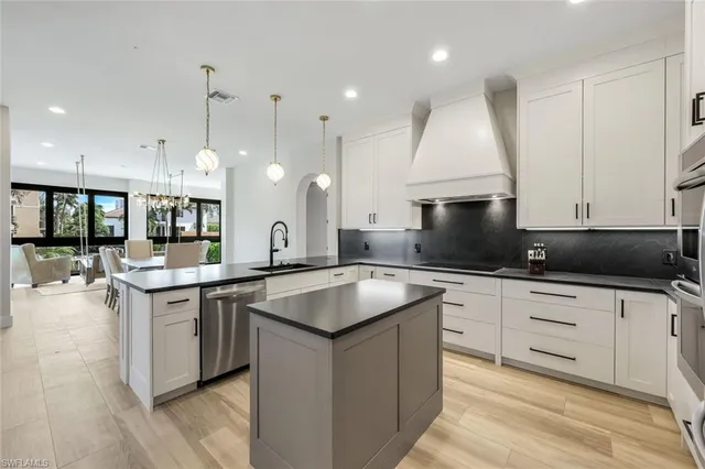 a kitchen with granite countertop a sink a counter top stainless steel appliances and cabinets