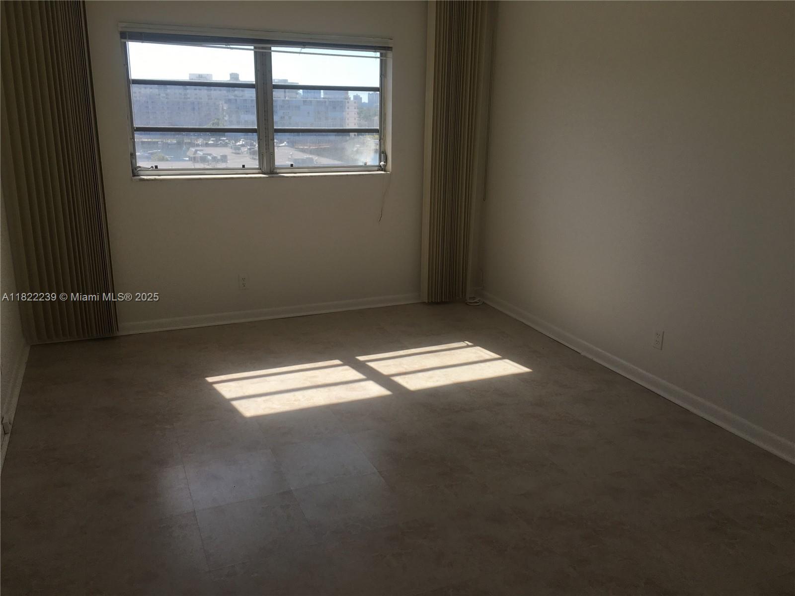 2200 East Hallandale Beach Boulevard, Unit 708 Hallandale Beach, FL 33009 - Photo 7 of 14 an empty room with a empty space and a window