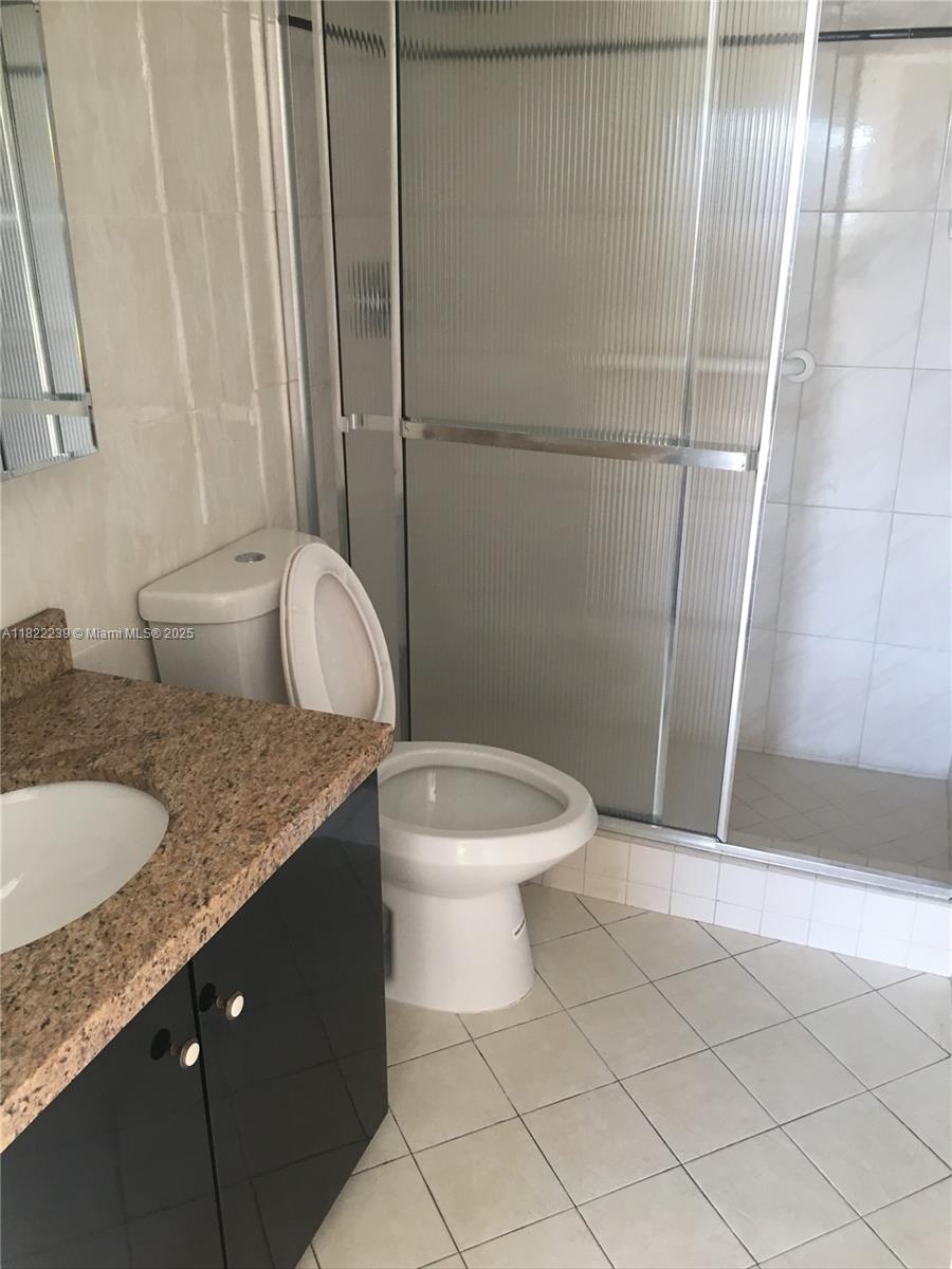2200 East Hallandale Beach Boulevard, Unit 708 Hallandale Beach, FL 33009 - Photo 8 of 14 a bathroom with a granite countertop sink toilet and shower