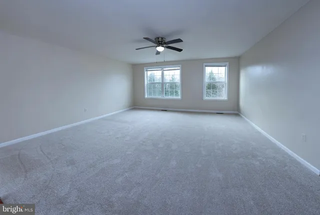 a view of a livingroom with a ceiling fan and window