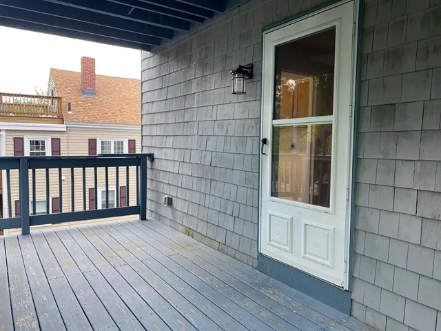 a view of a balcony with wooden floor and fence