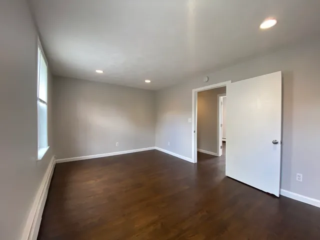 an empty room with wooden floor and entrance