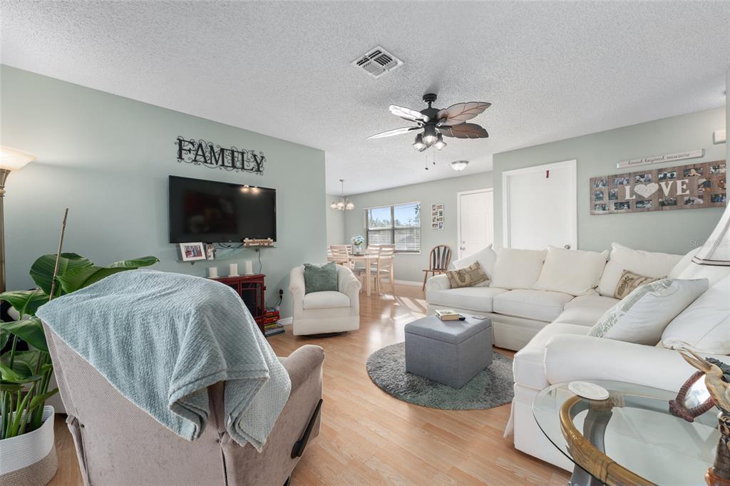 21373 Southwest Raintree Street Dunnellon, FL 34431 - Photo 14 of 39 a living room with furniture a flat screen tv and kitchen view