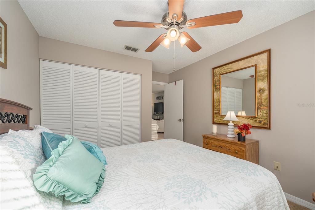 21373 Southwest Raintree Street Dunnellon, FL 34431 - Photo 24 of 39 a bedroom with a large bed and a chandelier