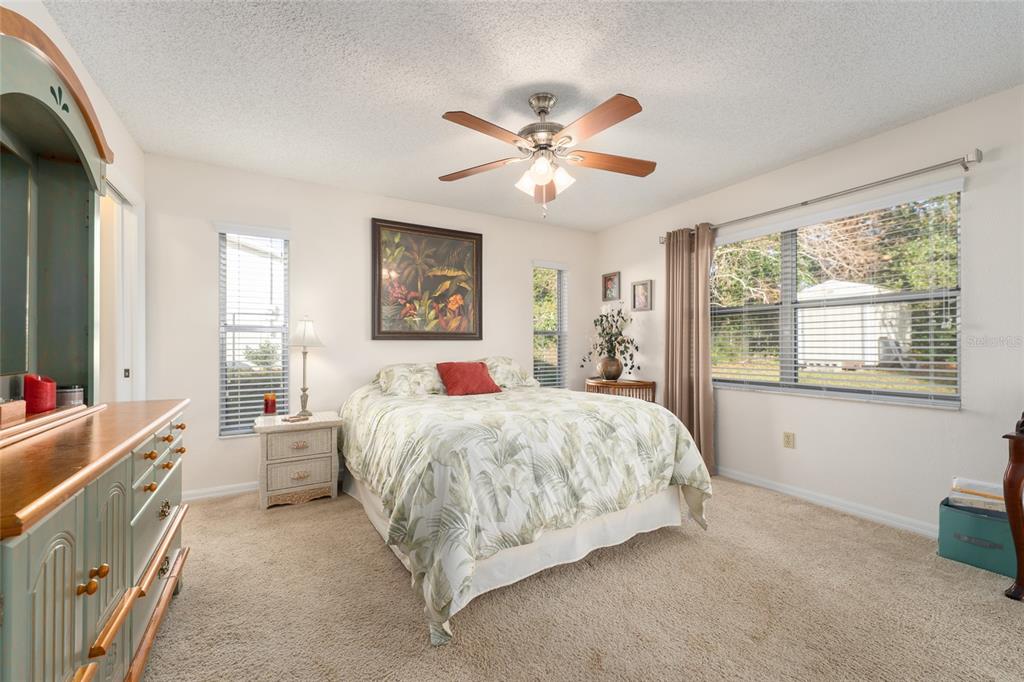 21373 Southwest Raintree Street Dunnellon, FL 34431 - Photo 27 of 39 a spacious bedroom with a bed and a chandelier
