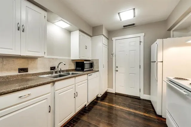 a kitchen with granite countertop white cabinets and white appliances