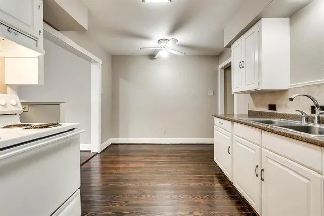 a kitchen with granite countertop white cabinets and white appliances