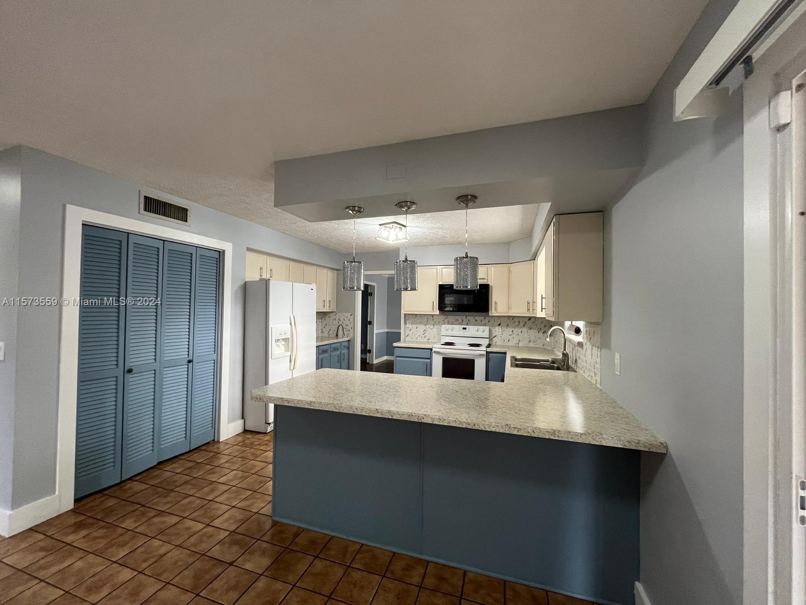 Confederate Point Jacksonville, FL 32210 - Photo 24 of 60 a large white kitchen with stainless steel appliances a sink and cabinets