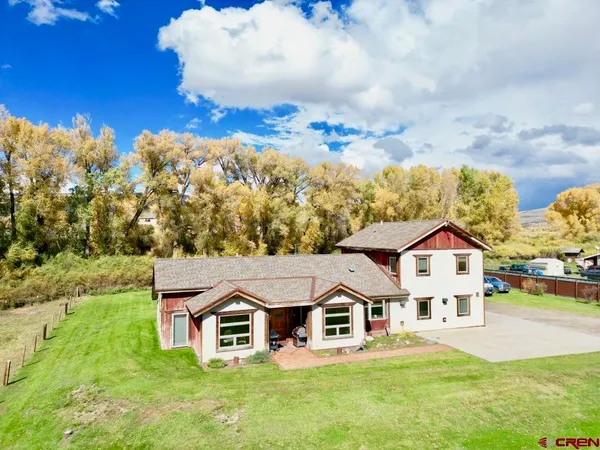 an aerial view of residential houses with yard and mountain view in back