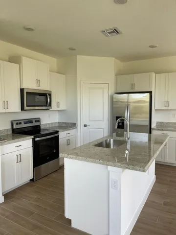 a kitchen with stainless steel appliances granite countertop a sink a stove and a refrigerator