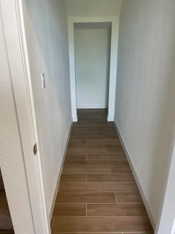 a view of a hallway with wooden floor and entryway