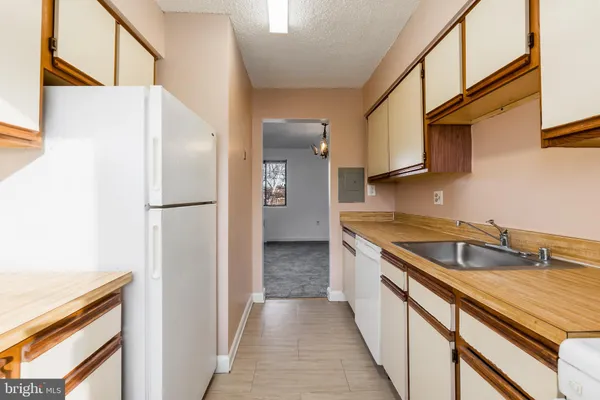 a kitchen with stainless steel appliances granite countertop a sink and a refrigerator