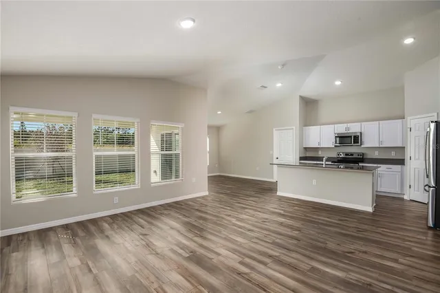 a view of kitchen with kitchen island granite countertop a stove top oven a sink and a granite counter top