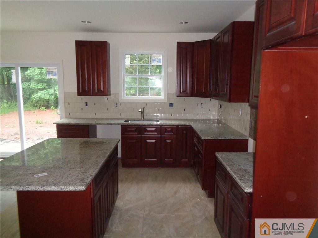 15 Altamont Road Edison, NJ 08817 - Photo 4 of 7 a kitchen with granite countertop a sink a stove and wooden cabinets