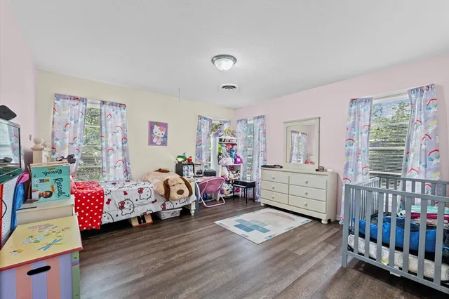 a large bedroom with a bed and a flat screen tv