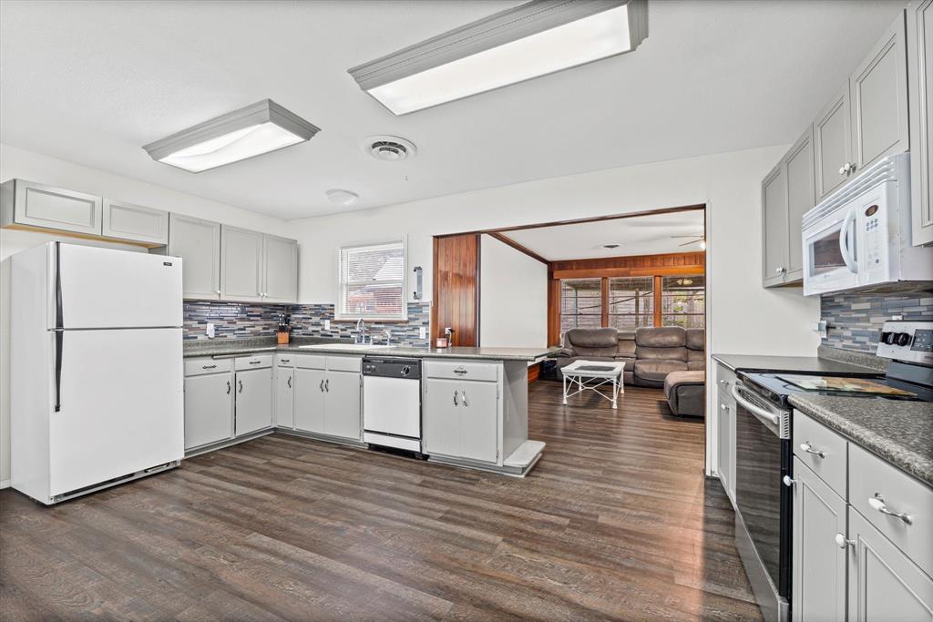 1208 Sunset Street Waco, TX 76710 - Photo 21 of 24 a kitchen with a refrigerator stove and white cabinets