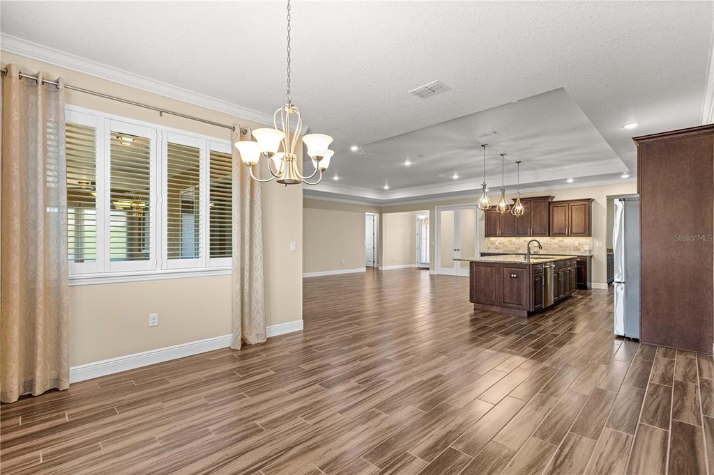 9460 Southwest 86th Place Ocala, FL 34481 - Photo 19 of 86 a view of a room with wooden floor and a kitchen