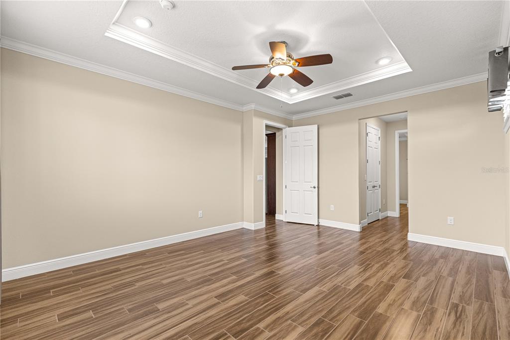 9460 Southwest 86th Place Ocala, FL 34481 - Photo 37 of 86 a view of an empty room with wooden floor and a ceiling fan