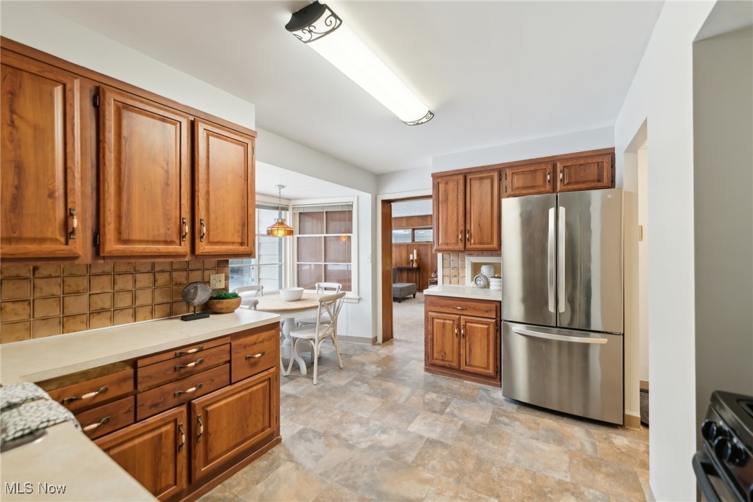 1542 Kew Road Cleveland, OH 44118 - Photo 12 of 23 Kitchen featuring stove, tasteful backsplash, and stainless steel refrigerator
