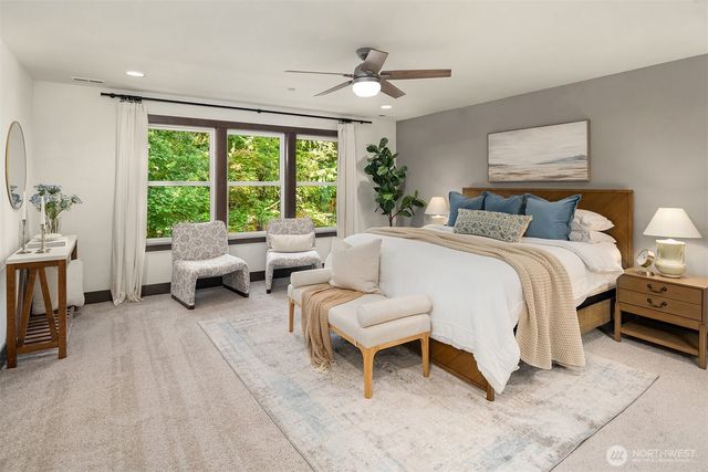 a spacious bedroom with a bed a couch and a large window