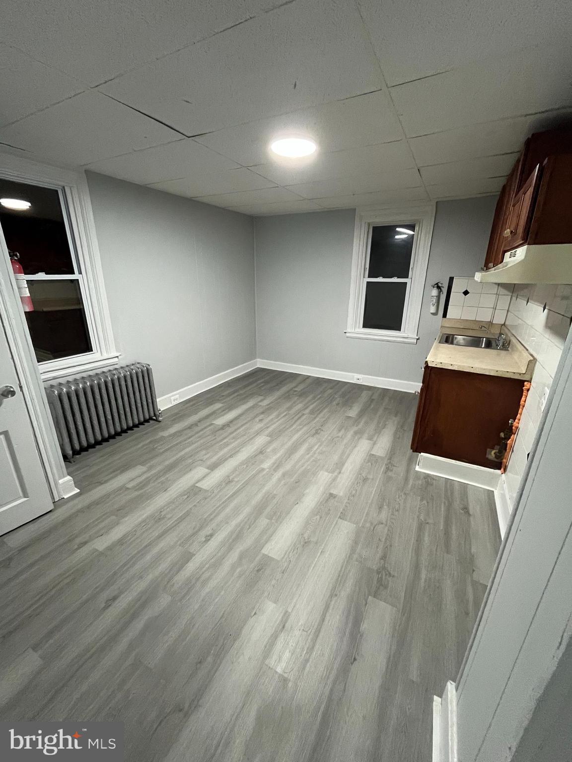 1115 Potter Street, Unit 2 Chester, PA 19013 - Photo 3 of 12 a view of kitchen and empty room with wooden floor