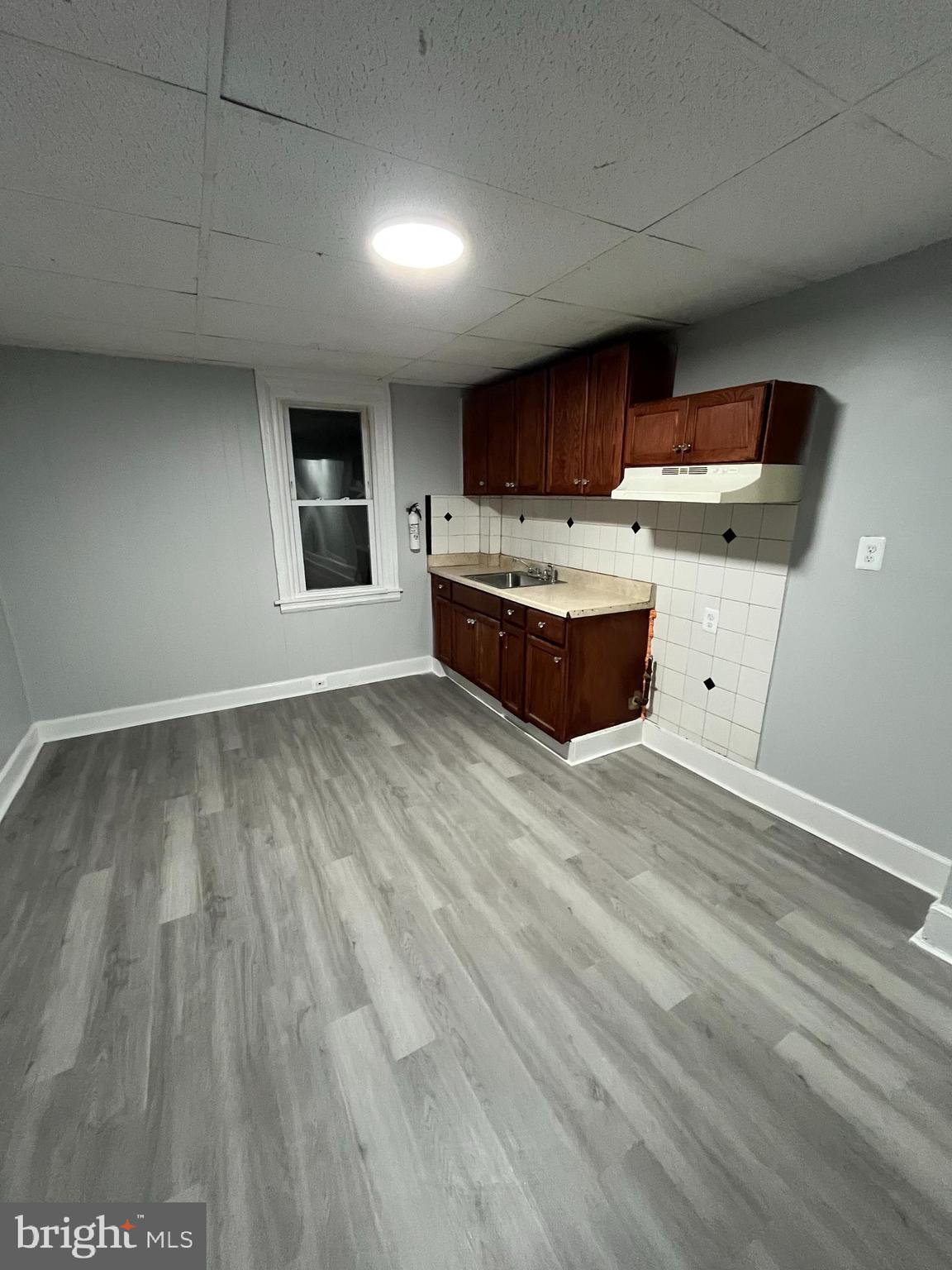 1115 Potter Street, Unit 2 Chester, PA 19013 - Photo 4 of 12 a view of kitchen with stainless steel appliances wooden floor and view of living room