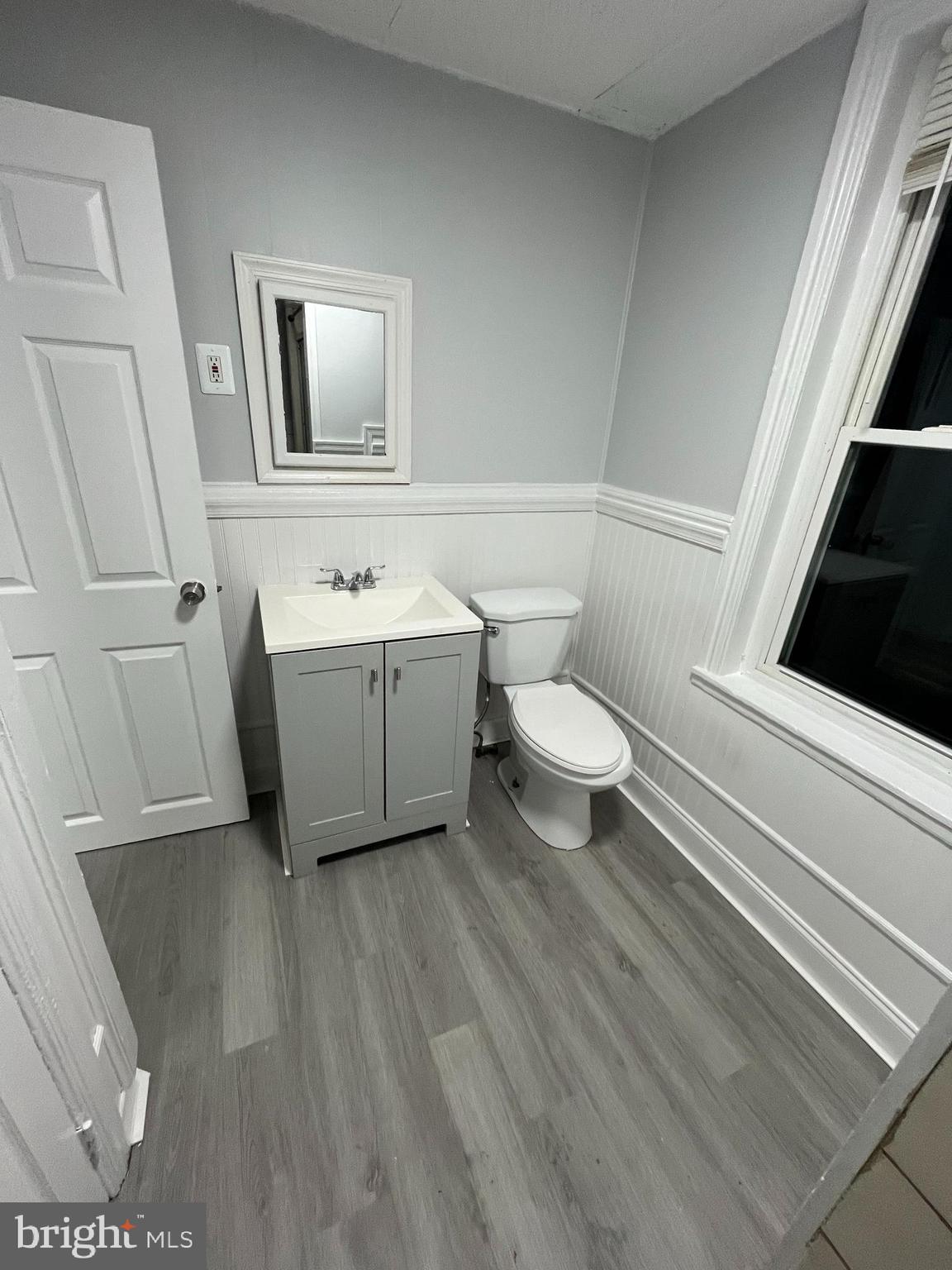 1115 Potter Street, Unit 2 Chester, PA 19013 - Photo 7 of 12 a bathroom with a toilet sink a mirror and vanity