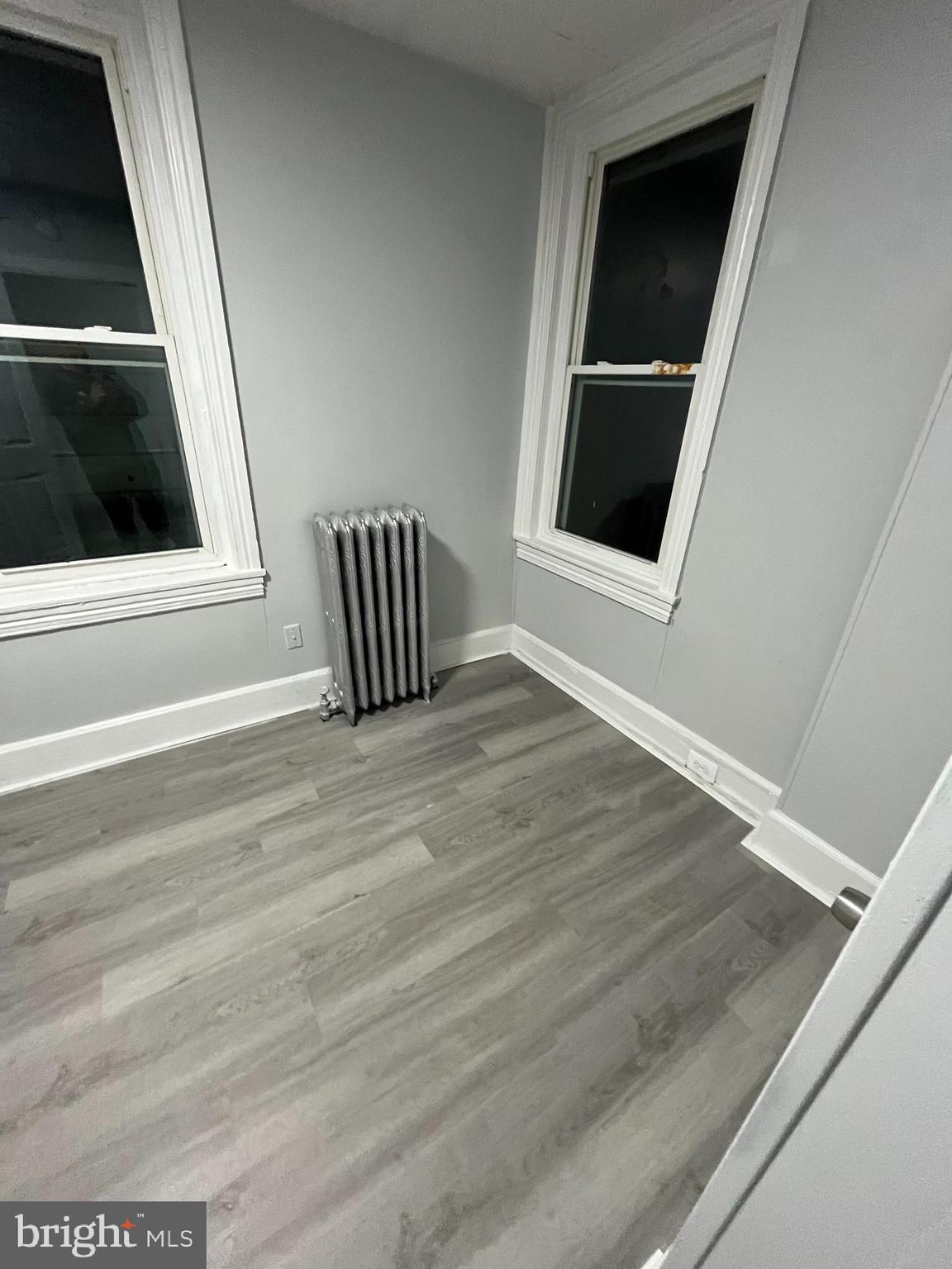 1115 Potter Street, Unit 2 Chester, PA 19013 - Photo 9 of 12 a view of an empty room with wooden floor and kitchen