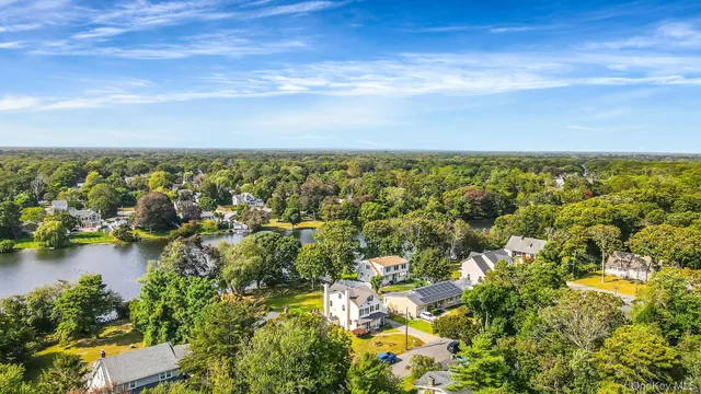 an aerial view of residential houses with outdoor space and trees
