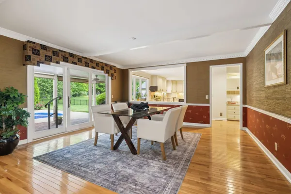 a kitchen with stainless steel appliances granite countertop a refrigerator a stove top oven a sink dishwasher and white cabinets with wooden floor