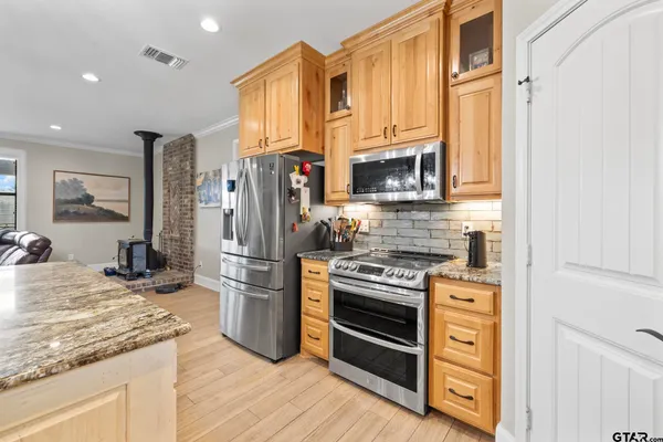 a kitchen with stainless steel appliances granite countertop a stove refrigerator and a microwave