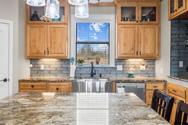 a kitchen with stainless steel appliances granite countertop a stove a sink and a microwave
