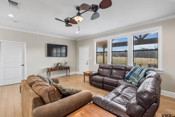 a living room with furniture ceiling fan and a window