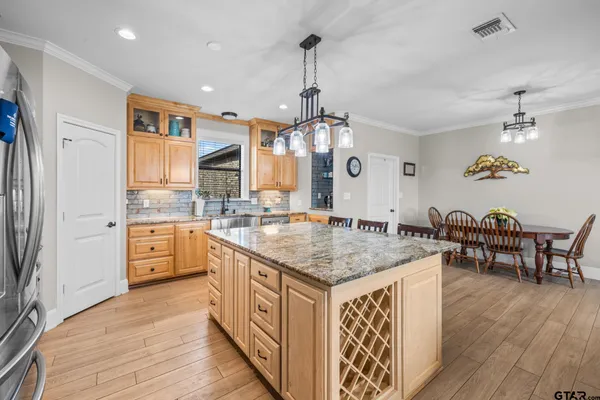 a kitchen with stainless steel appliances granite countertop a kitchen island a stove and a sink