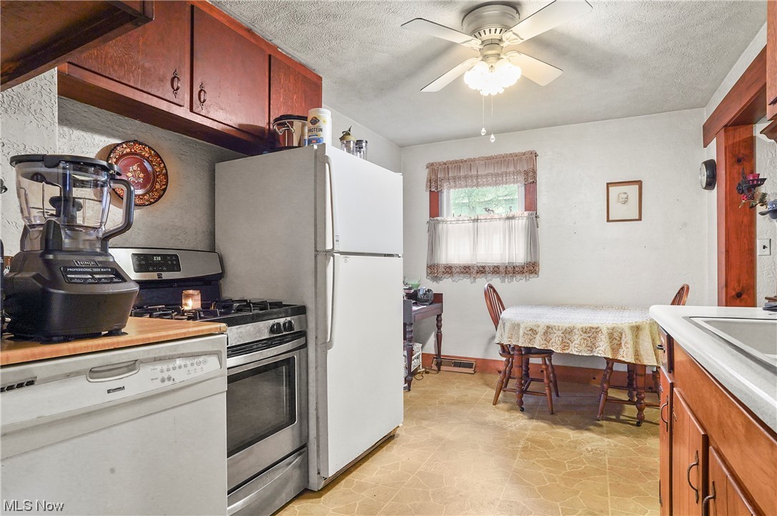 13745 Chillicothe Road Novelty, OH 44072 - Photo 21 of 31 Kitchen featuring light tile floors, ceiling fan, a textured ceiling, dishwasher, and gas stove
